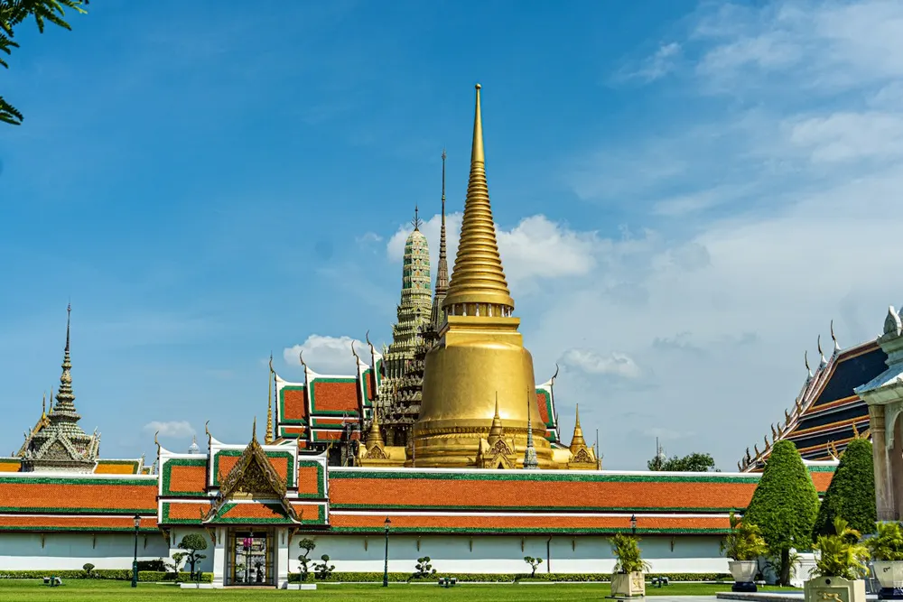 Golden spires of the Grand Palace under a blue sky