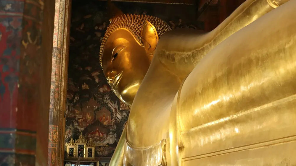 Large golden Buddha statue inside a temple hall