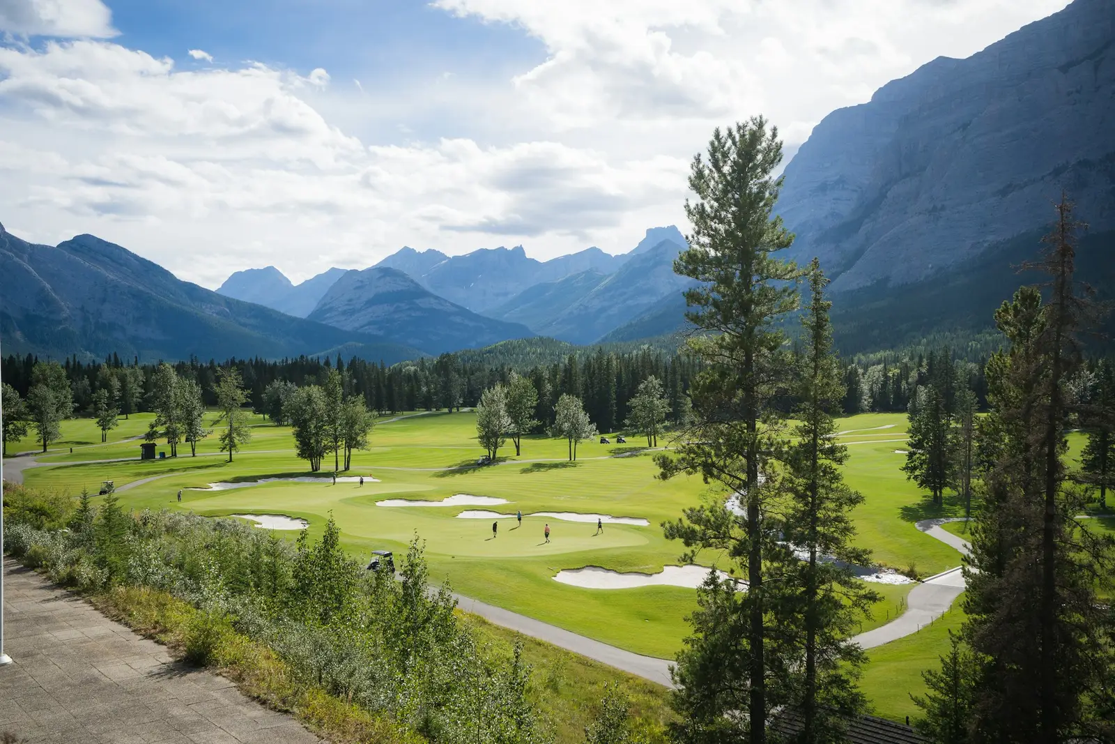 Green golf course with mountains in the background