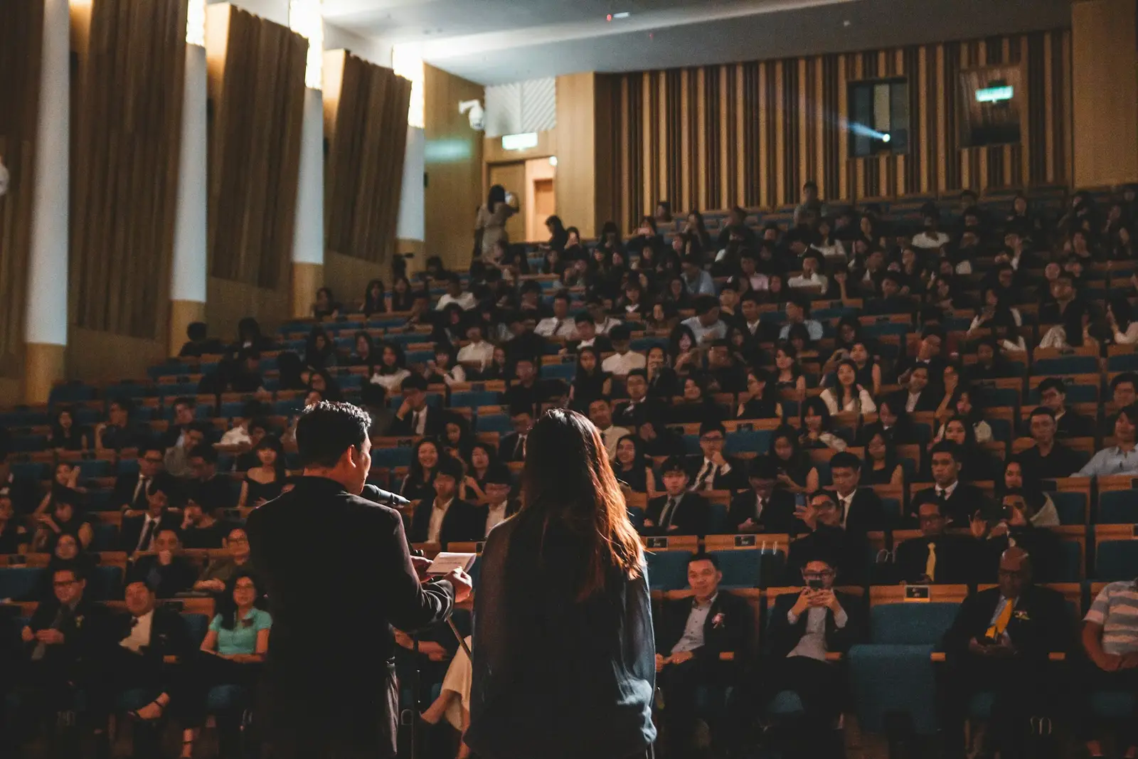 Delegates seated in a conference hall listening to a speaker